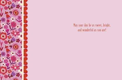 Inside of a light pink greeting card with a floral border on the left and the message 'May your day be as sweet, bright, and wonderful as you are!'.