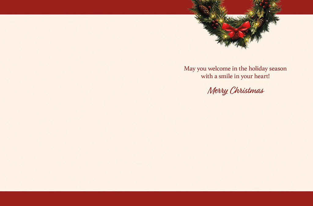 Inside of a holiday greeting card with a simple, elegant message in red script: 'May you welcome in the holiday season with a smile in your heart! Merry Christmas.' A small festive green wreath with a red bow decorates the top right corner.