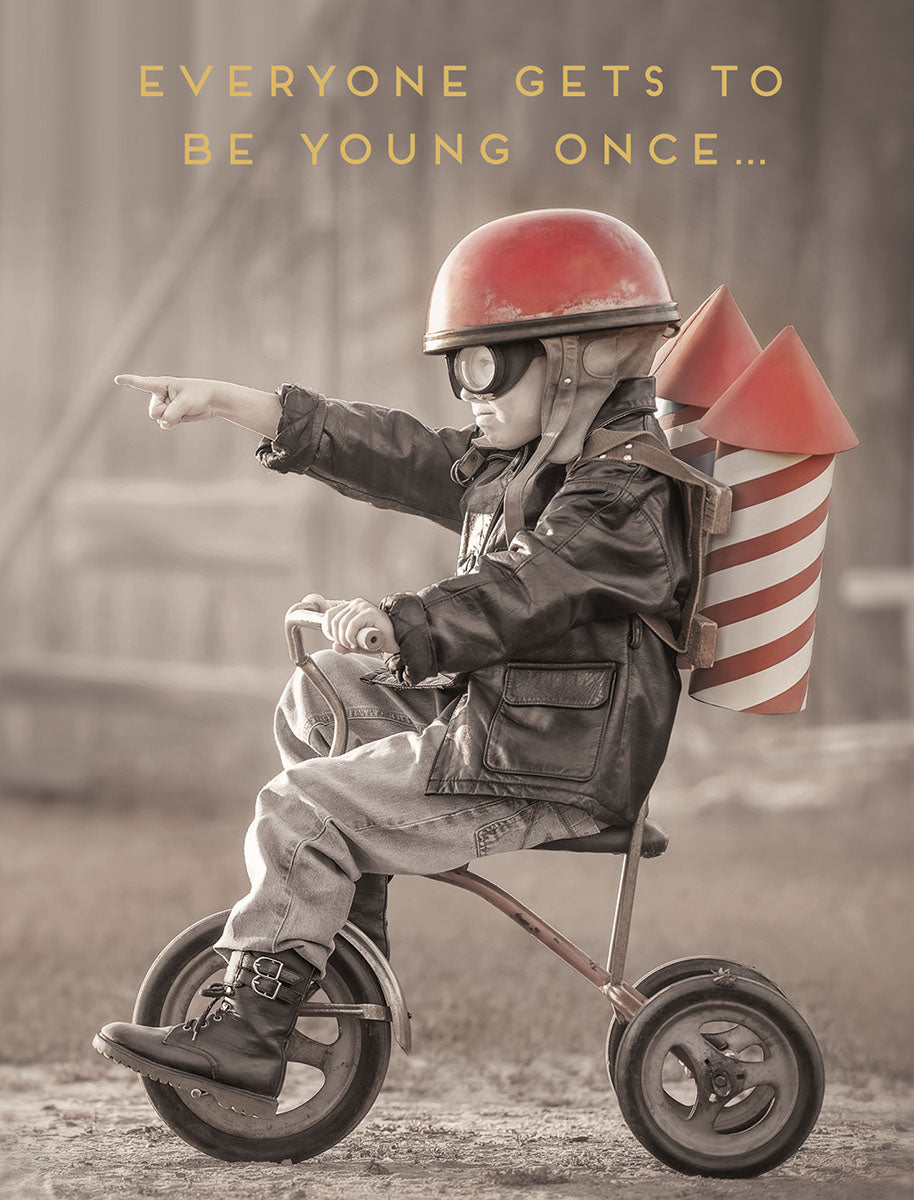 Funny greeting card for him, featuring a retro sepia photo of a child in a pilot helmet with a rocket backpack on a tricycle, pointing forward. The card reads 'EVERYONE GETS TO BE YOUNG ONCE...' perfect for a friend's milestone celebration.