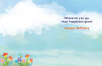 Interior of a lighthearted birthday card showing a serene sky and field with wildflowers, with the message 'Wherever you go, may happiness grow! Happy Birthday' in stylish font.