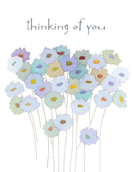Greeting card cover with 'thinking of you' text above a field of various pastel-colored flowers with distinct centers.