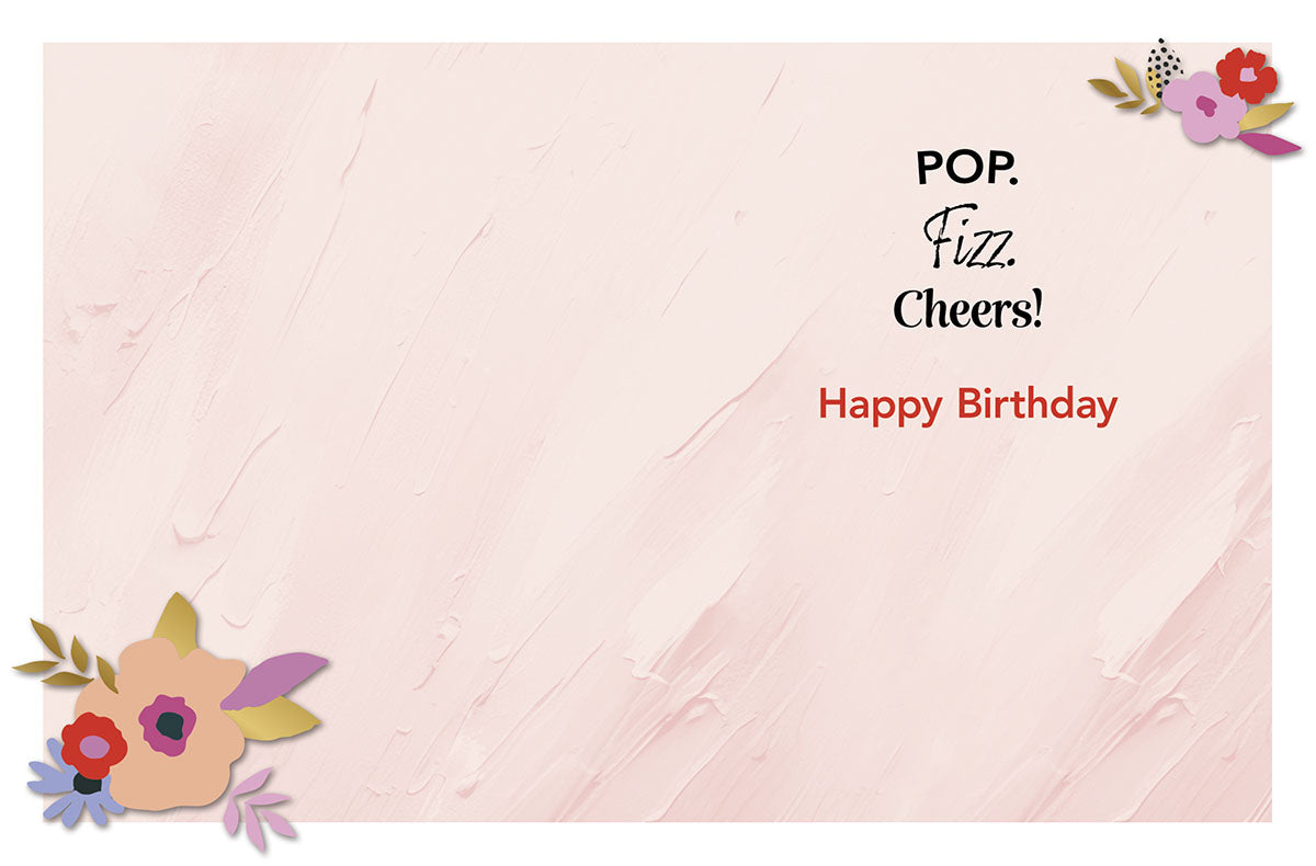 Inside of a cheerful greeting card with 'POP. Fizz. Cheers! Happy Birthday' text, accompanied by delicate floral accents on a soft pink background.
