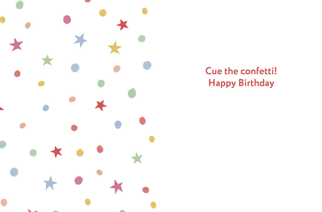 Inside of a playful birthday greeting card. The left side is covered with a pattern of colorful confetti and stars. The right side features the text 'Cue the confetti! Happy Birthday'.