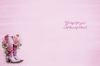 Inside of a pink greeting card with a subtle brushstroke texture, featuring a small illustration of pink floral cowboy boots on the bottom left and the heartfelt message "Grateful for your wild, beautiful heart." on the right.