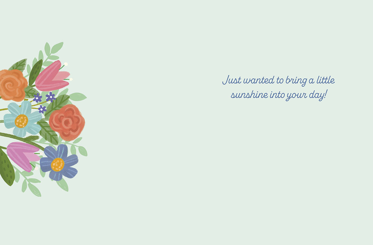Inside of a get well greeting card with an illustration of colorful flowers on the left border and the message 'Just wanted to bring a little sunshine into your day!' on a light blue background.