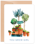 Front view of an encouraging 'You Grow Girl' birthday greeting card for her, featuring a beautiful watercolor illustration of various potted green plants and trees with a small 'love' sign. Perfect for a friend.