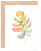 Front view of a blank greeting card featuring a vibrant watercolor monstera leaf design with intricate gold mandala details, accompanied by a kraft paper envelope.