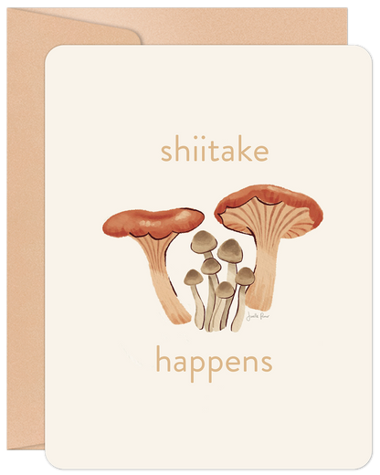 Front of an encouragement card with 'shiitake happens' text and an illustration of various brown and tan mushrooms.