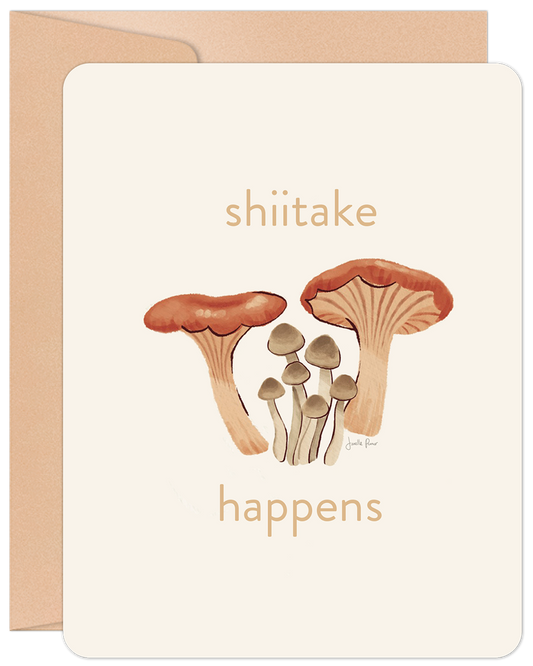 Front of an encouragement card with 'shiitake happens' text and an illustration of various brown and tan mushrooms.