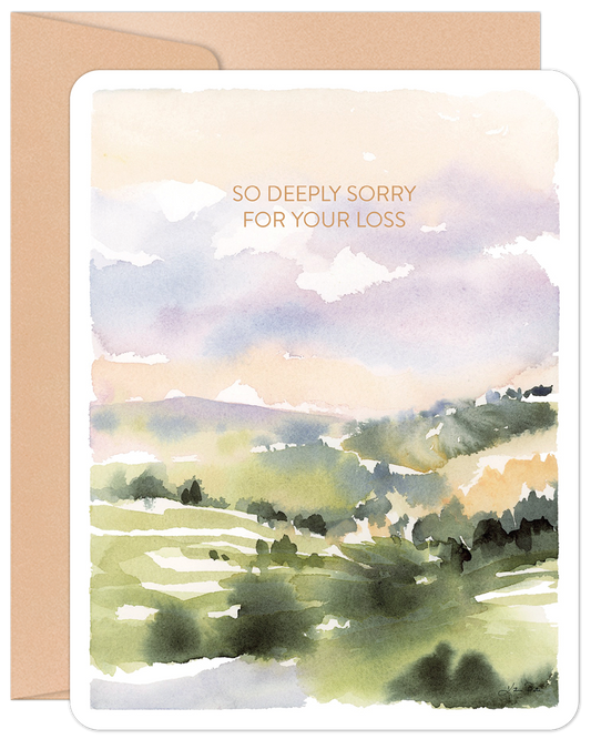 Front of a heartfelt sympathy card with a peaceful watercolor landscape of green hills and a pastel sky, featuring the text 'SO DEEPLY SORRY FOR YOUR LOSS' and a coordinating brown envelope.
