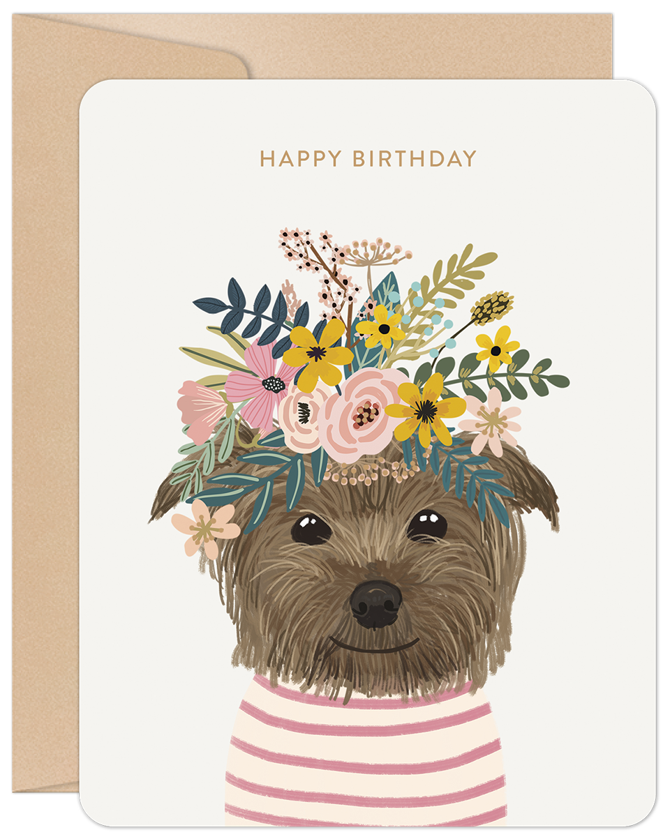Cute brown terrier dog wearing a vibrant floral crown with yellow, pink, and green flowers, on a cream greeting card with 'HAPPY BIRTHDAY' text, perfect for a friend.