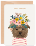 Cute brown terrier dog wearing a vibrant floral crown with yellow, pink, and green flowers, on a cream greeting card with 'HAPPY BIRTHDAY' text, perfect for a friend.