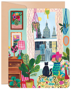 SEO-optimized alt description for a greeting card featuring a vibrant illustration of a cozy indoor scene. A black cat sits on a patterned sofa, looking out a window at a city skyline. The room is decorated with numerous potted plants, macrame hangers, colorful lamps, and framed artwork, creating a cheerful, artistic, and inviting atmosphere. The card has rounded corners and a brown envelope visible behind it.