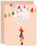 Vibrant birthday greeting card featuring a clear balloon filled with 'Happy Birthday' confetti, colorful tassels, and a string of festive bunting on a blush pink background, perfect for any celebration.
