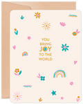 Joyful greeting card featuring a cream background with scattered colorful floral, star, and rainbow motifs. Central text reads 'YOU BRING JOY TO THE WORLD' with a vibrant blue and orange eye graphic in 'JOY'. Perfect for expressing heartfelt appreciation.