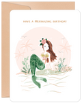 Charming mermaid greeting card for kids featuring a whimsical illustration of a brown-haired mermaid with a floral crown and green tail, sitting on a sandy beach with palm trees, wishing 'Have a Mermazing Birthday'.