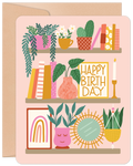 Cute plant shelf greeting card featuring potted greenery, books, a 'HAPPY BIRTHDAY' sign, and bohemian decor on a soft pink background. Ideal for plant lovers.