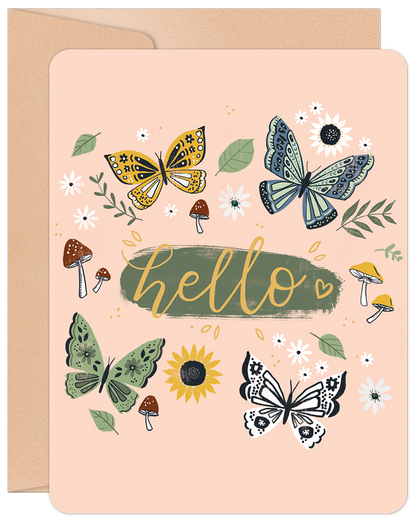 Front of a charming greeting card featuring colorful butterflies, whimsical mushrooms, and scattered flowers with 'hello' in cursive on a light pink background.