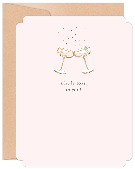Elegant anniversary card featuring two champagne glasses toasting with sparkling gold accents on a blush pink background, text reads 'a little toast to you!'