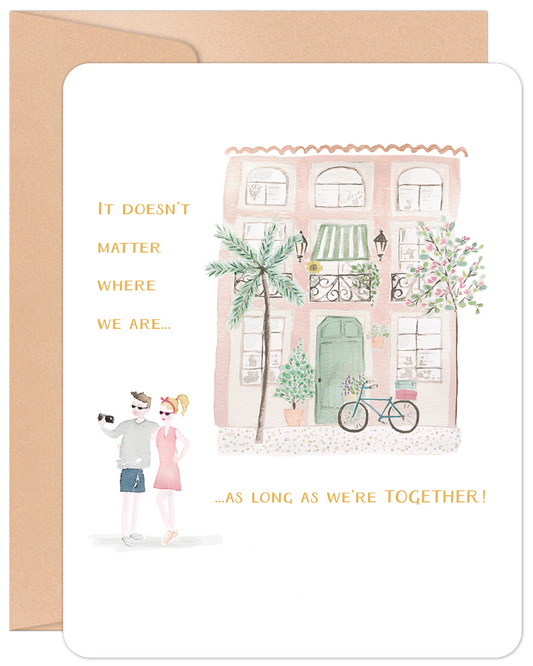Front of 'Home Is Wherever' anniversary card, featuring a charming pink house watercolor and a couple taking a selfie, with heartfelt text.