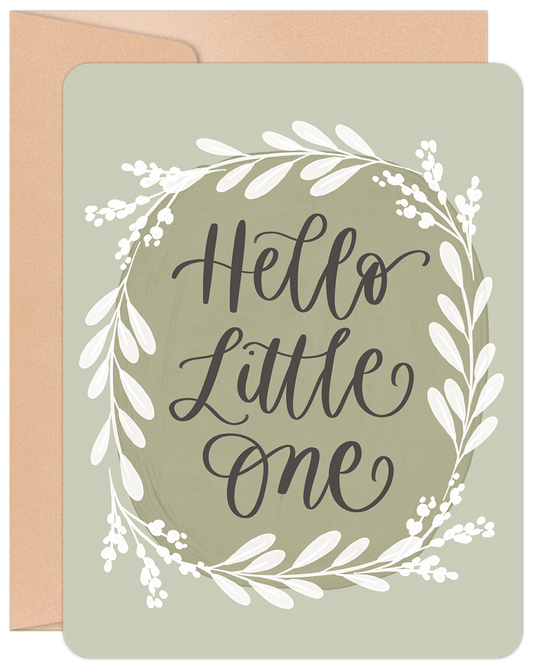 Front of a 'Hello Little One' new baby greeting card with elegant green leaves wreath on a sage background.