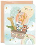 Cute hot air balloon greeting card featuring a giraffe, alligator, zebra, toucan, and tiger celebrating a tiny traveler's arrival, set against a starlit sky with a rainbow.