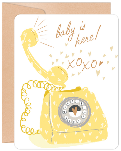 Front of 'Baby is Here' card with a whimsical yellow rotary phone, scattered hearts, and 'baby is here! xoxo'. Perfect for new parents.