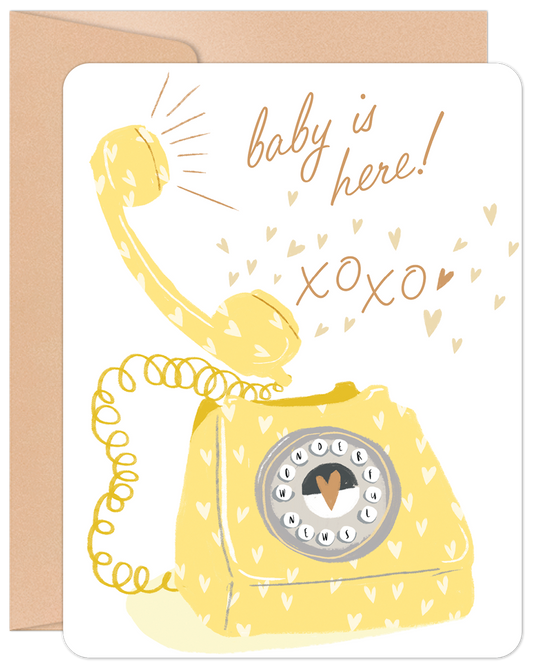 Front of 'Baby is Here' card with a whimsical yellow rotary phone, scattered hearts, and 'baby is here! xoxo'. Perfect for new parents.