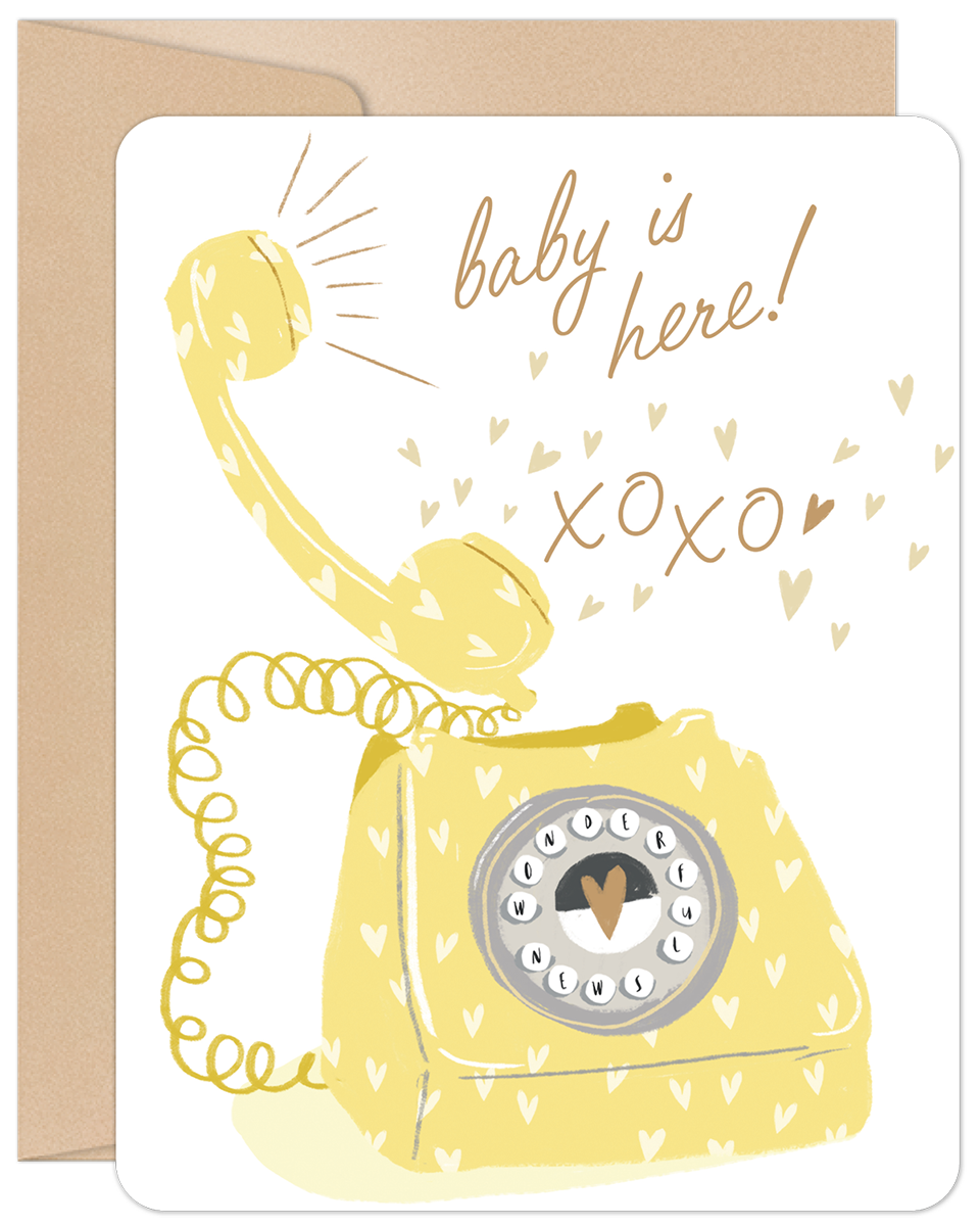 Front view of a cute new baby greeting card featuring a yellow vintage telephone, hearts, and text 'baby is here! xoxo' on a white background, accompanied by a brown envelope.