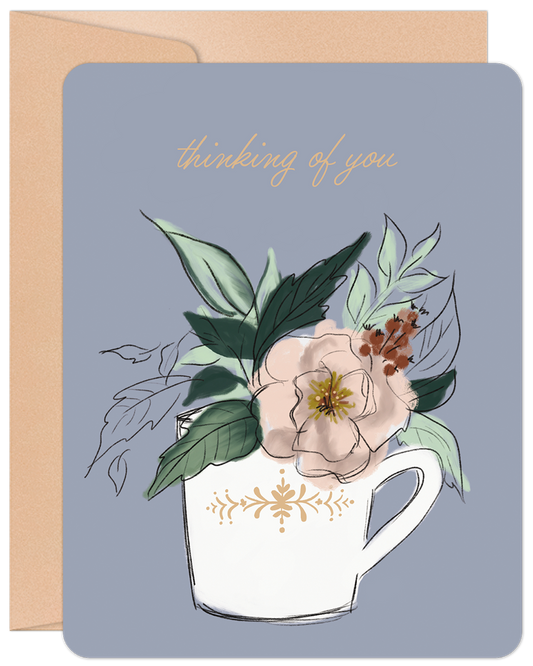 Front of a 'Thinking of You' greeting card featuring a delicate floral arrangement in a decorative teacup on a light blue background.