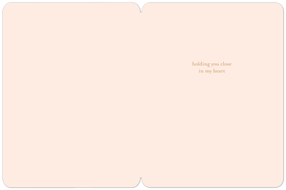 Inside of a light peach sympathy card with text 'holding you close in my heart' on the right side.