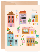 Front of a cheerful new home greeting card featuring an illustration of colorful houses, trees, and flowers with the words 'HAPPY COZY HOME' on a light beige background.