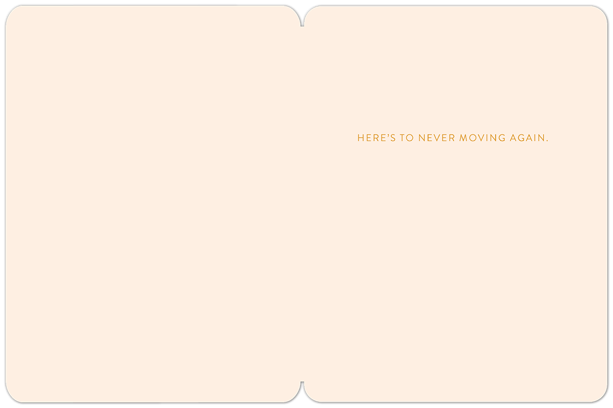 Inside of a housewarming greeting card, blank on the left, with the message 'HERE'S TO NEVER MOVING AGAIN.' printed in gold lettering on the right peach-colored panel.