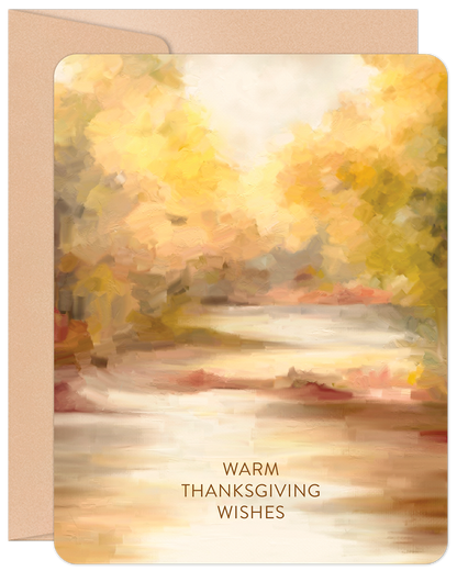 Front of a watercolor greeting card featuring an impressionistic autumn forest scene with golden leaves, a winding path, and 'Warm Thanksgiving Wishes' text. It comes with a kraft paper envelope.