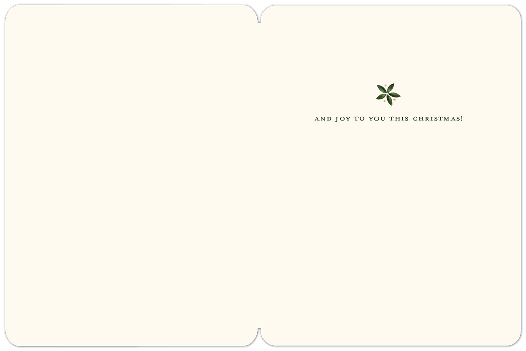 Inside of a classic holiday greeting card, blank for personalization, with a small green leaf accent and the message 'AND JOY TO YOU THIS CHRISTMAS!' in elegant font.
