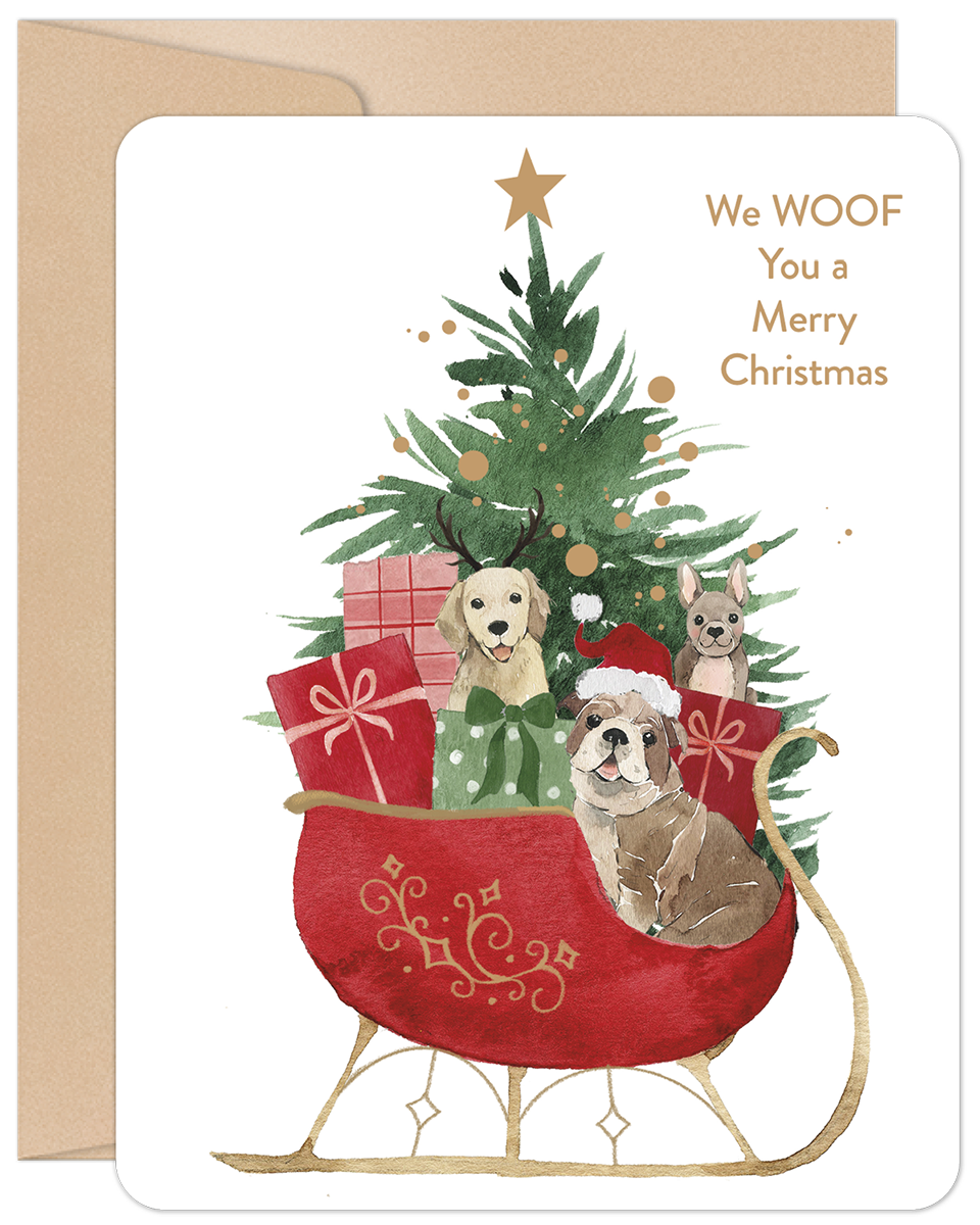 Front of a festive holiday greeting card featuring a watercolor illustration of three adorable dogs (Golden Retriever, Bulldog, small terrier mix) in a red sleigh filled with gifts, pulled by a dog. A star-topped holiday tree stands behind the sleigh. Text reads: 'We WOOF You a Merry Christmas'.