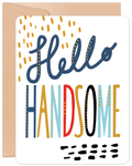 Front of a modern birthday greeting card featuring 'Hello Handsome' in playful, multi-colored (blue, gold, red, black) lettering with decorative dots on a white background, perfect for a special man.