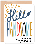 Front of a modern birthday greeting card featuring 'Hello Handsome' in playful, multi-colored (blue, gold, red, black) lettering with decorative dots on a white background, perfect for a special man.