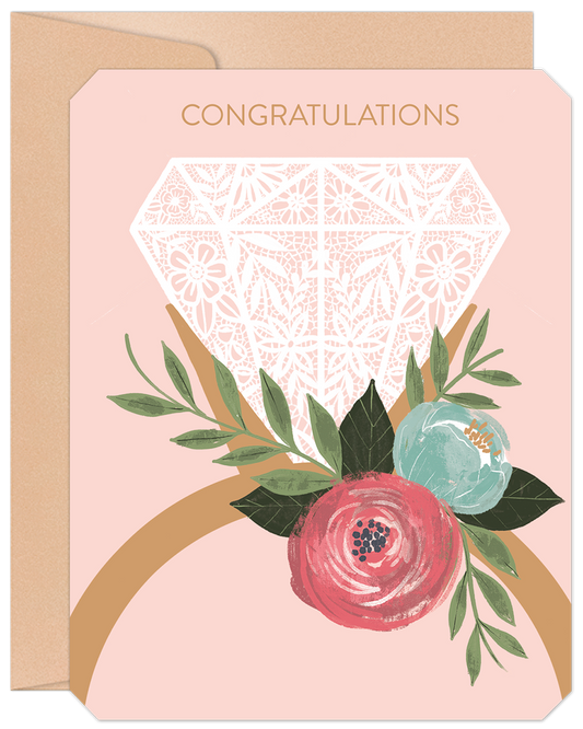 Front of a pink congratulations card featuring a white lace-patterned diamond ring and a colorful floral bouquet design.