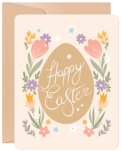 Front of a Happy Easter greeting card featuring a large brown egg with 'Happy Easter' in white script, surrounded by colorful spring flowers on a light pink background.