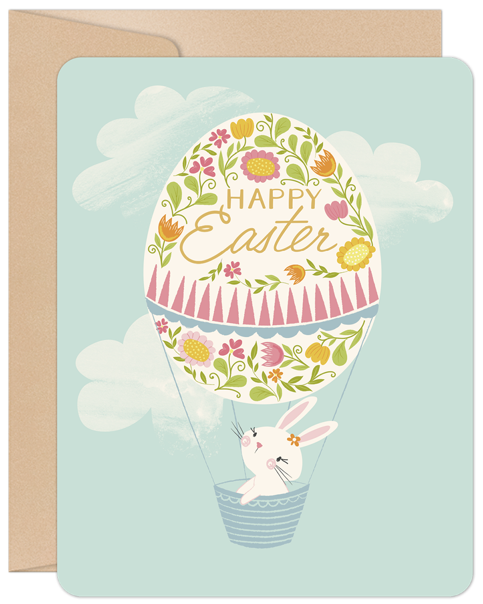 Whimsical bunny in floral egg hot air balloon greeting card, light blue sky with clouds, perfect for springtime celebrations and children.