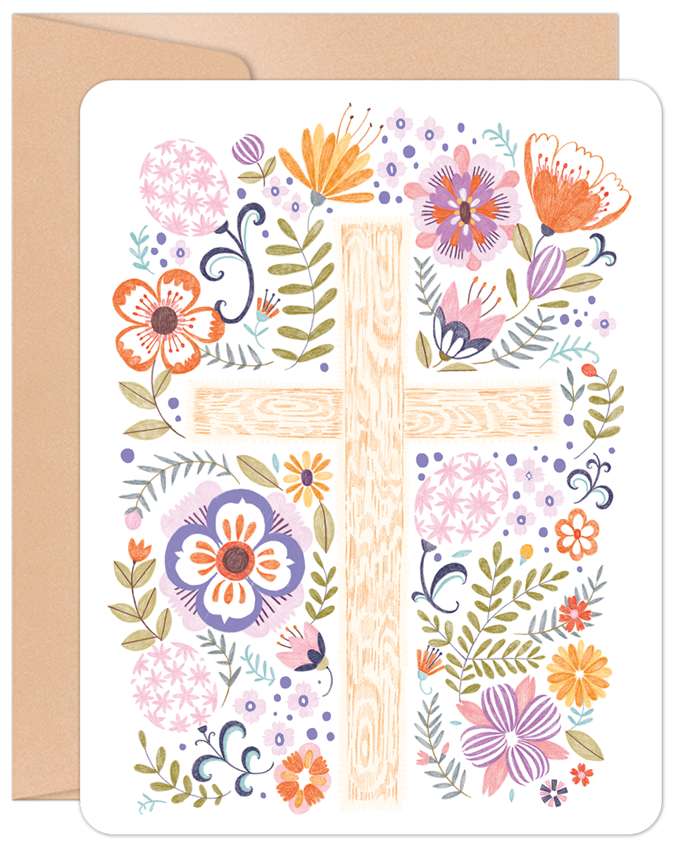 Front of a greeting card featuring a folk-art style wooden cross adorned with an abundance of colorful flowers and greenery.