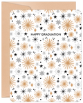 Front view of an inspiring graduation greeting card featuring gold, silver, and black starbursts on a white background, next to a kraft paper envelope. The card reads 'HAPPY GRADUATION'.