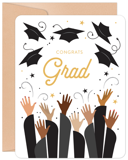 Front of a graduation greeting card showing hands tossing caps, gold 'Congrats Grad' text, and stars on a white background.