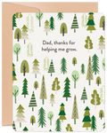 Front of a Father's Day greeting card featuring a whimsical forest of green evergreen and deciduous trees on a cream background. The text reads 'Dad, thanks for helping me grow.' A rustic kraft paper envelope is visible behind the card.