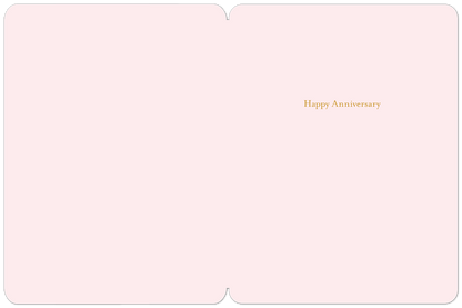 Inside of a soft pink anniversary card with "Happy Anniversary" written in elegant gold script.