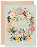 Pastel floral congratulations card with 'Congrats!' text, featuring a botanical wreath design and a subtle kraft envelope.