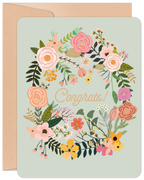 Pastel floral congratulations card with 'Congrats!' text, featuring a botanical wreath design and a subtle kraft envelope.