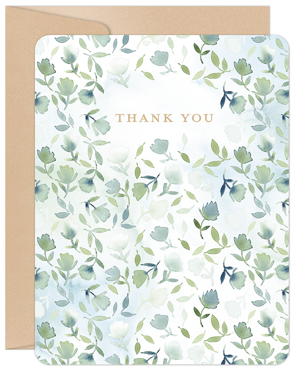 Front of a 'Thank You' greeting card with watercolor green and blue floral design, accompanied by a kraft envelope.