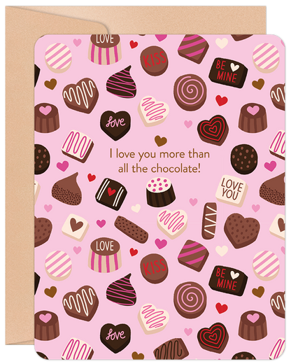 Front of a pink Valentine's Day card covered in chocolate and heart patterns, with the text "I love you more than all the chocolate!".